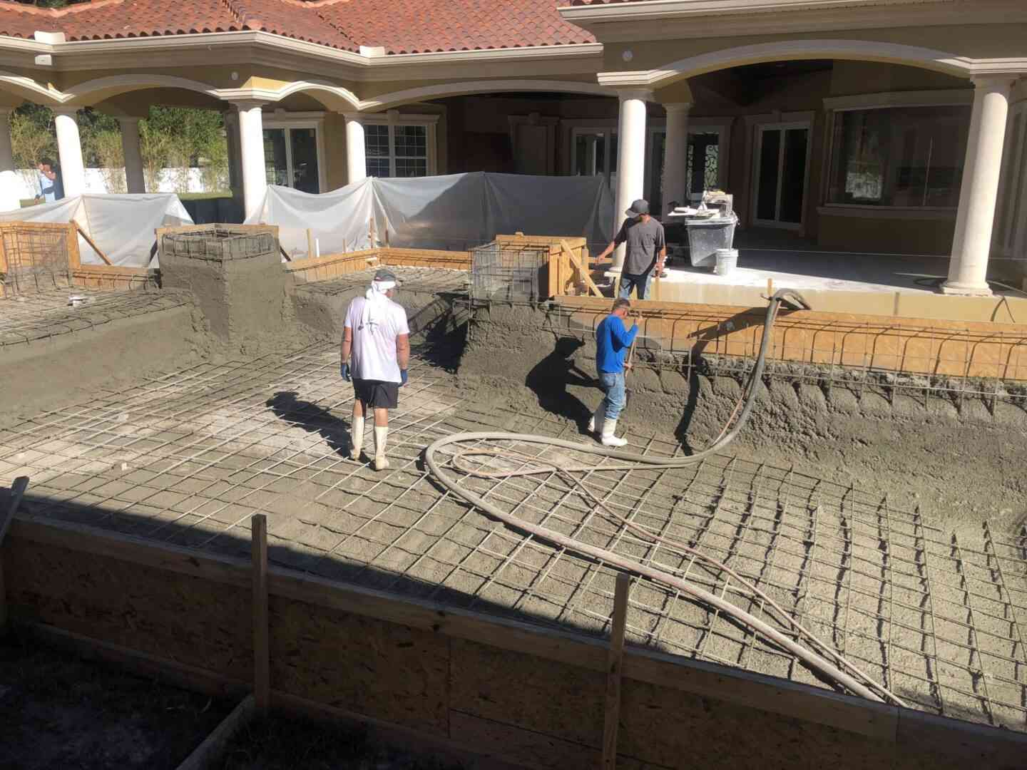 Construction workers cementing a pool structure
